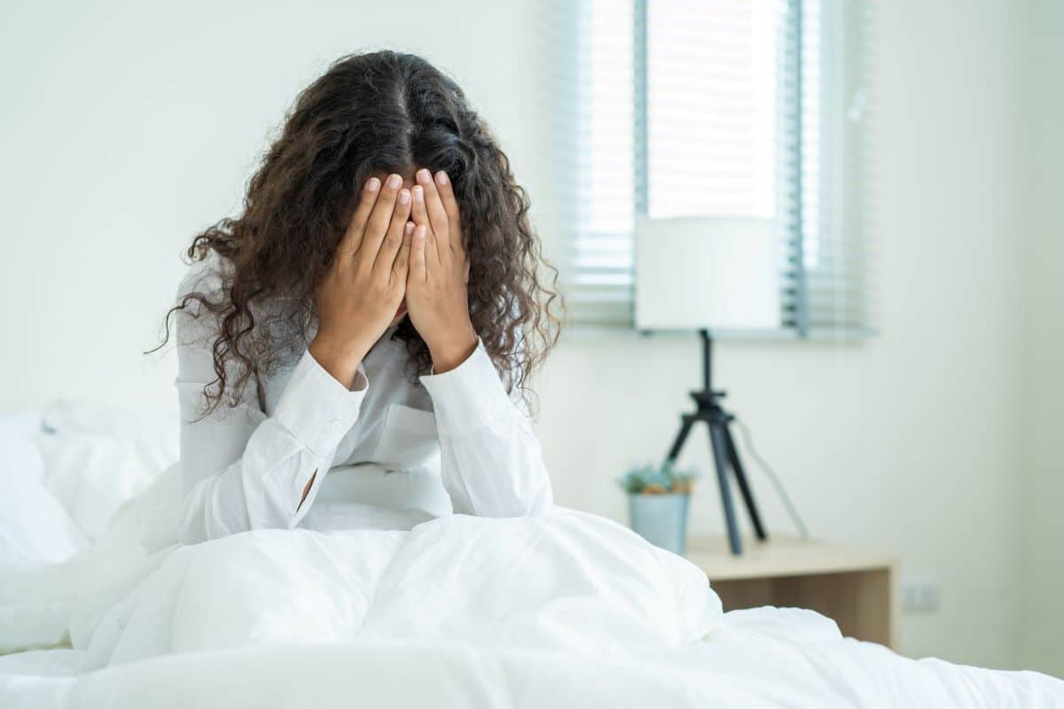 woman-in-bed-hands-over-face-loss-of-drive